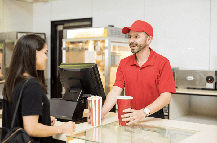 Cinema worker giving order to the customer