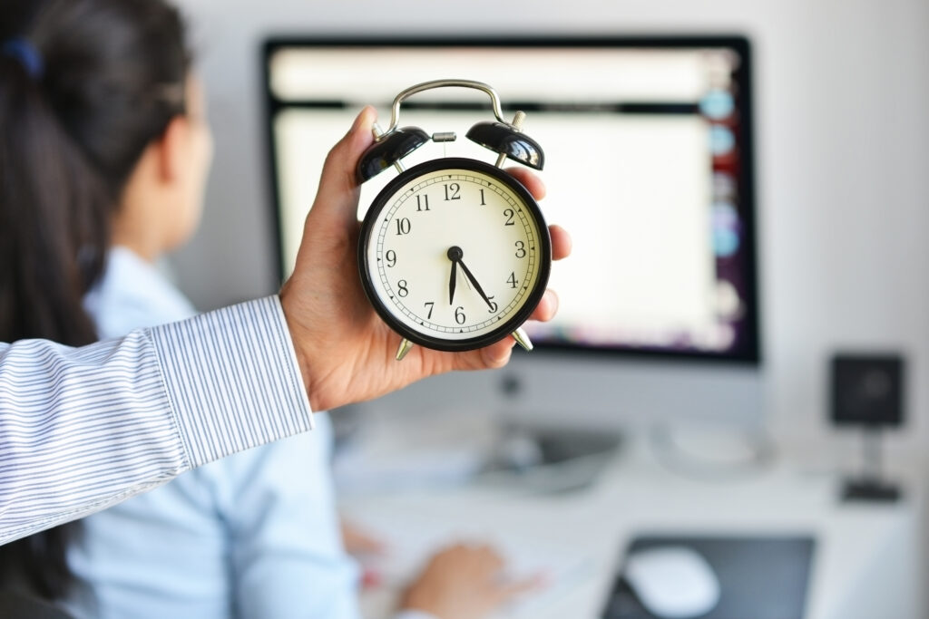 Person holding clock in hand