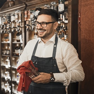 Smiling bartender polishing glass