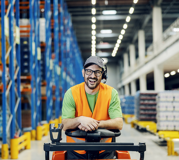 Smiling worker behind the wheel of forklift