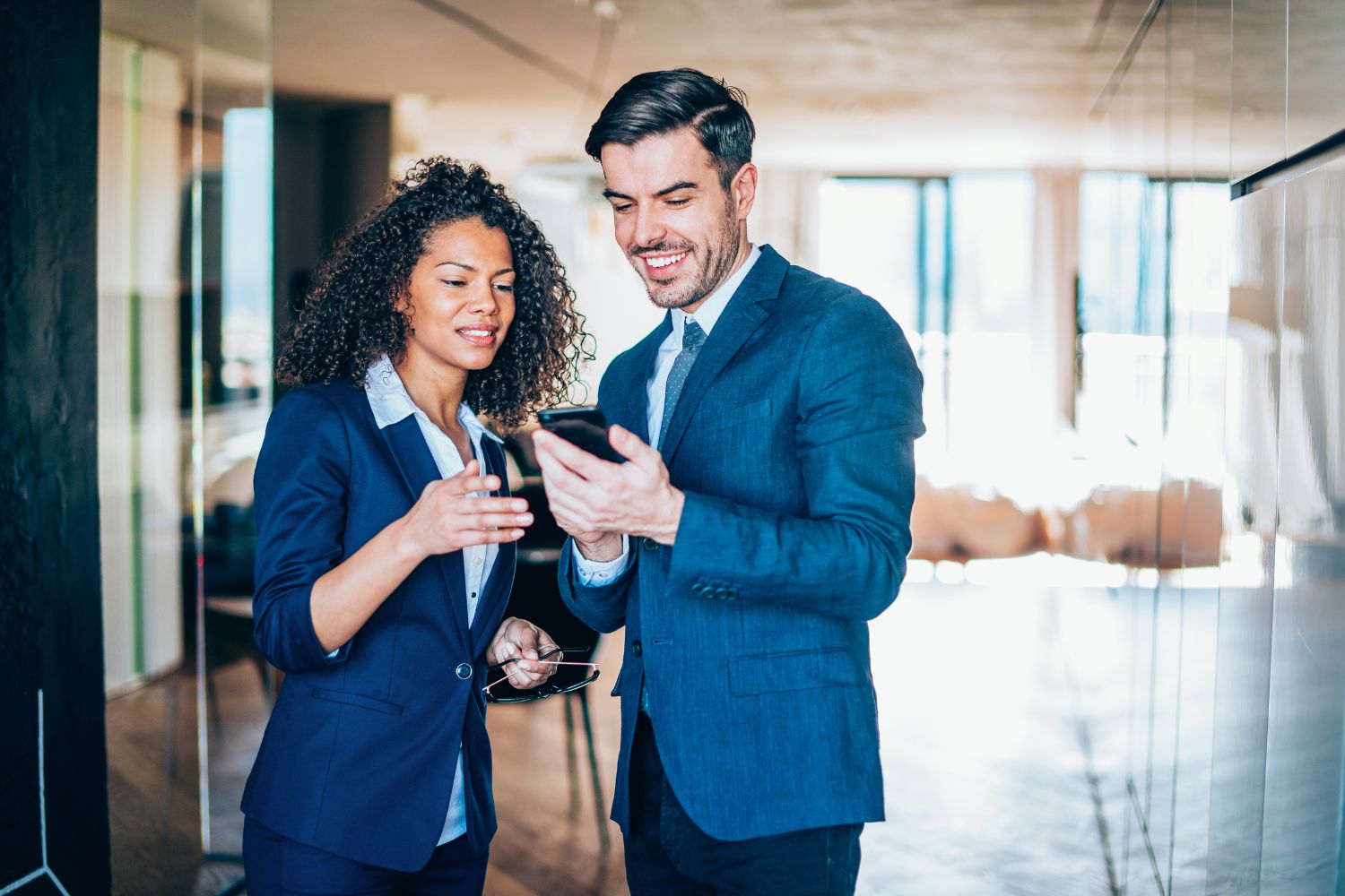 Two coworkers reviewing a shift notification on a mobile phone